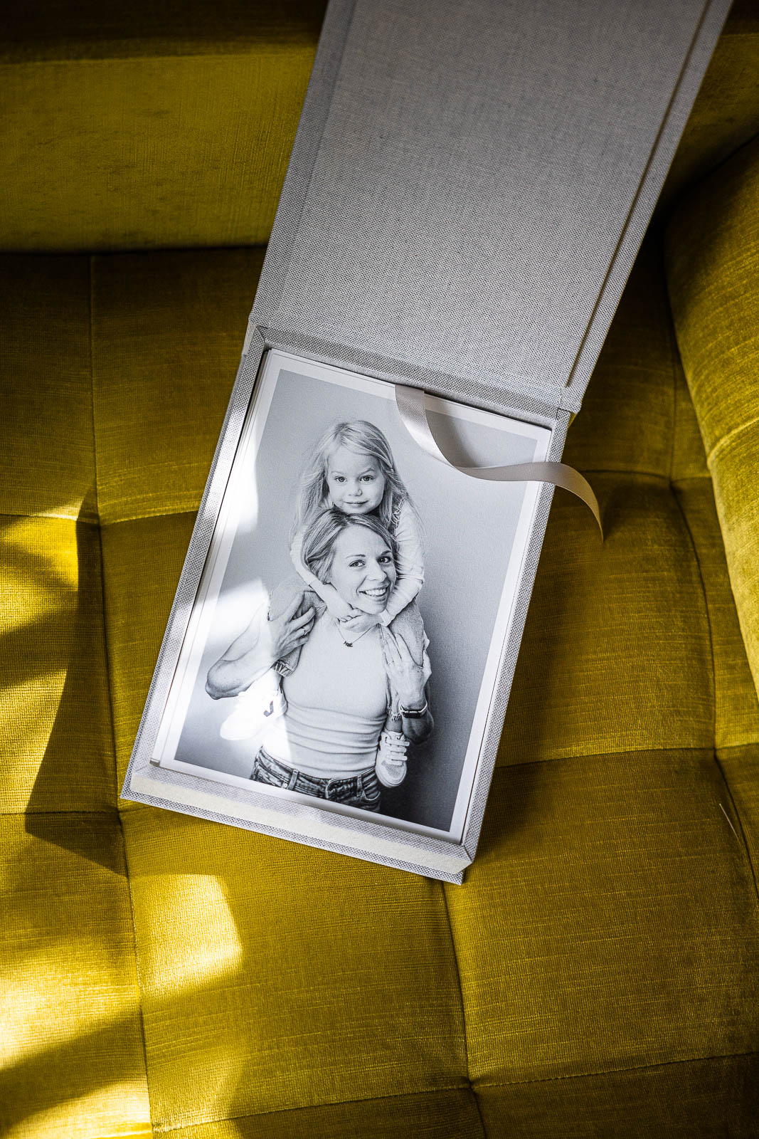 Fotobox mit Fineart Prints auf gelbem Sessel