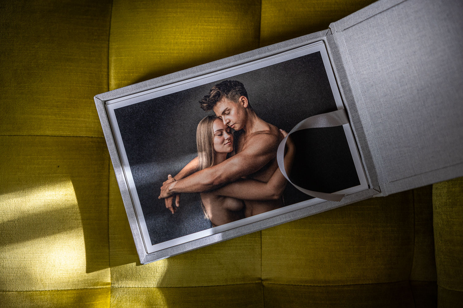 Fotobox mit Fineart Prints auf gelbem Sessel